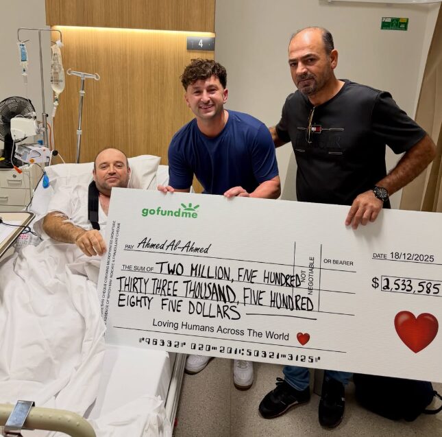 Zachery presenting an oversized fundraiser check at a hospital bedside