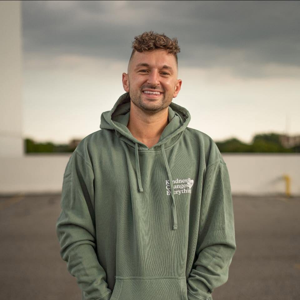 Zachery Dereniowski portrait in a Kindness Changes Everything hoodie