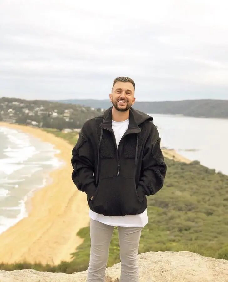 Zachery Dereniowski on a clifftop over a Sydney beach